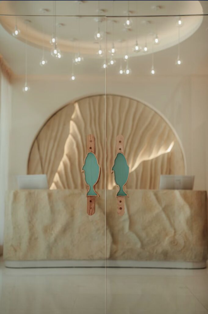 Detalle de manijas en forma de pez en las puertas de vidrio de la recepción del Spa JOIA, Iberostar Aruba
