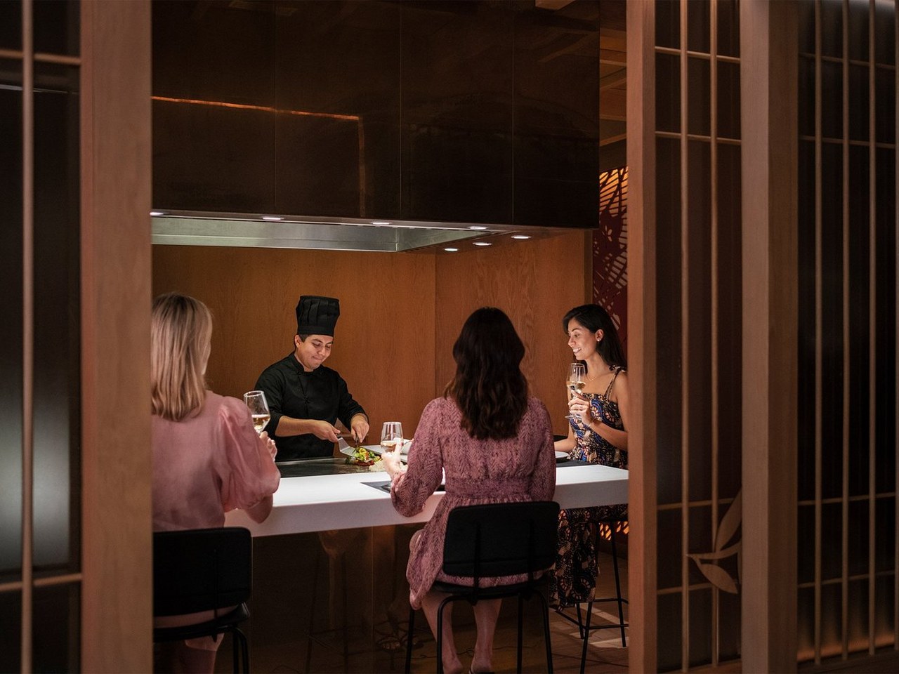 Estación de Teppanyaki interactiva con chef cocinando frente a comensales