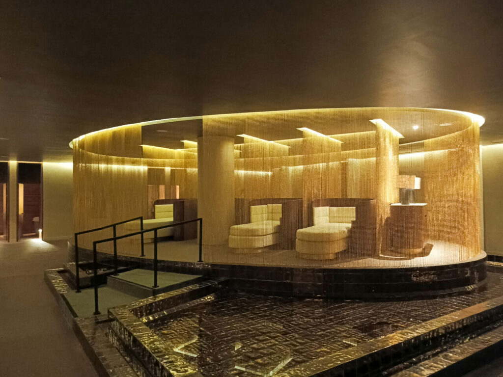 Pieza circular central envuelta en flecos dorados con sillones a medida
