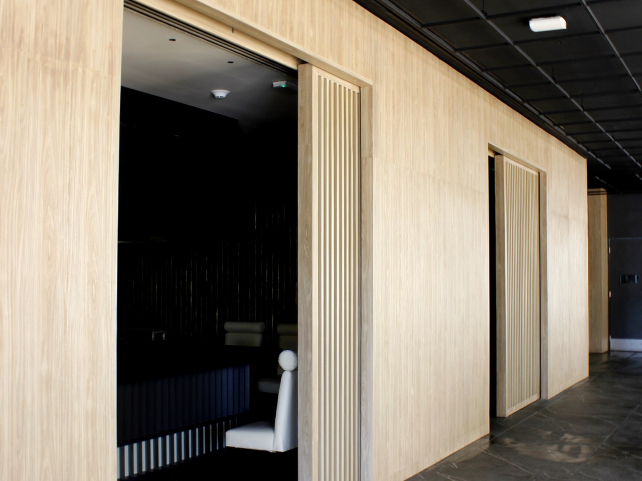 Pasillo con puertas corredizas en celosía de madera