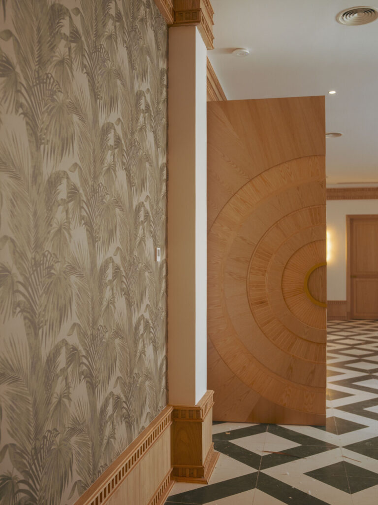 Puerta monumental y papel tapiz, detalle de cenefa en madera