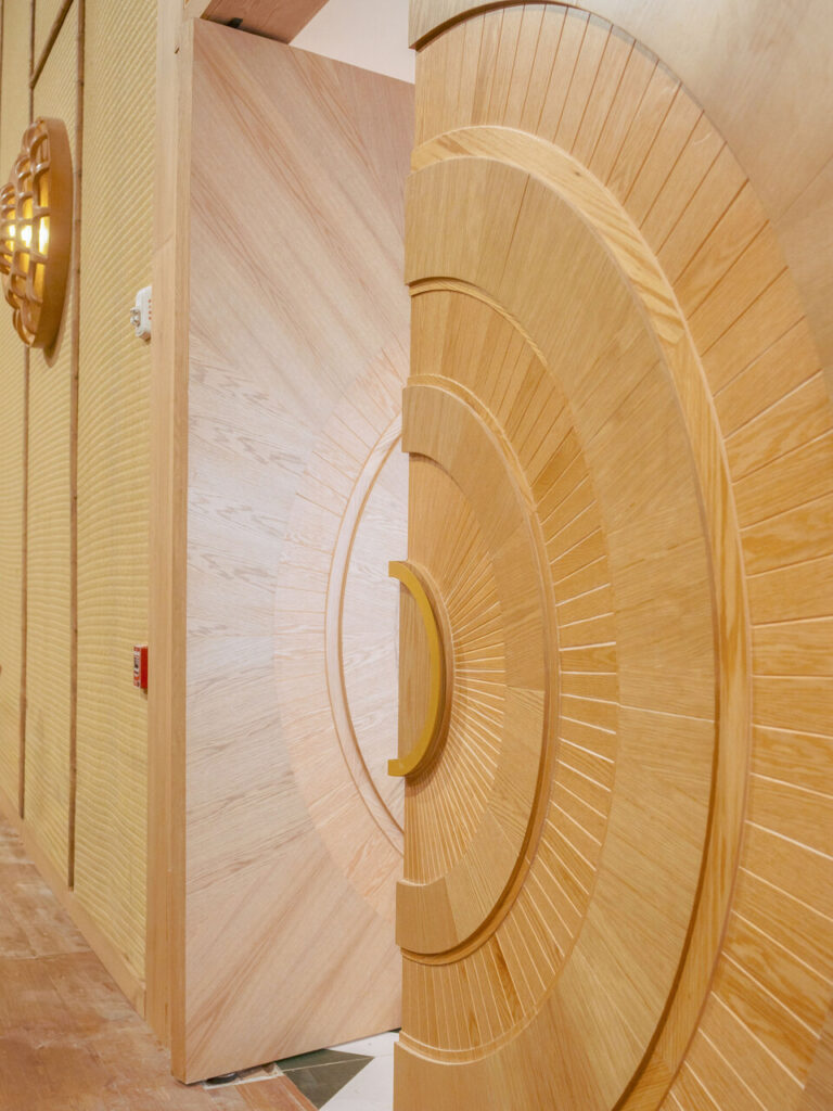 Puerta circular CNC, close-up dramático