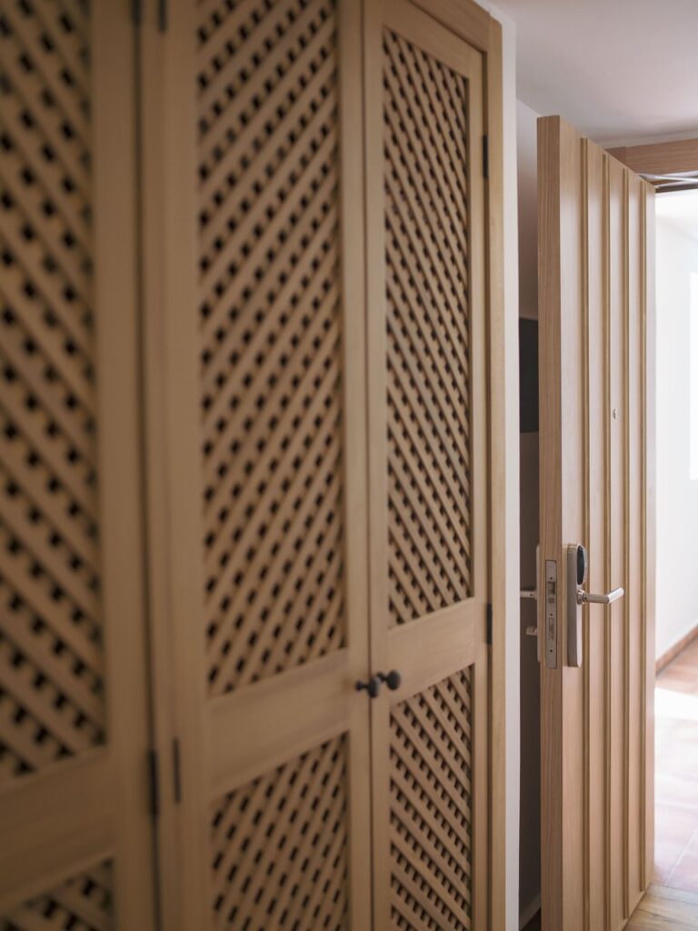 Closet con puertas de celosía diagonal de madera en habitación de Ocean Coral & Turquesa