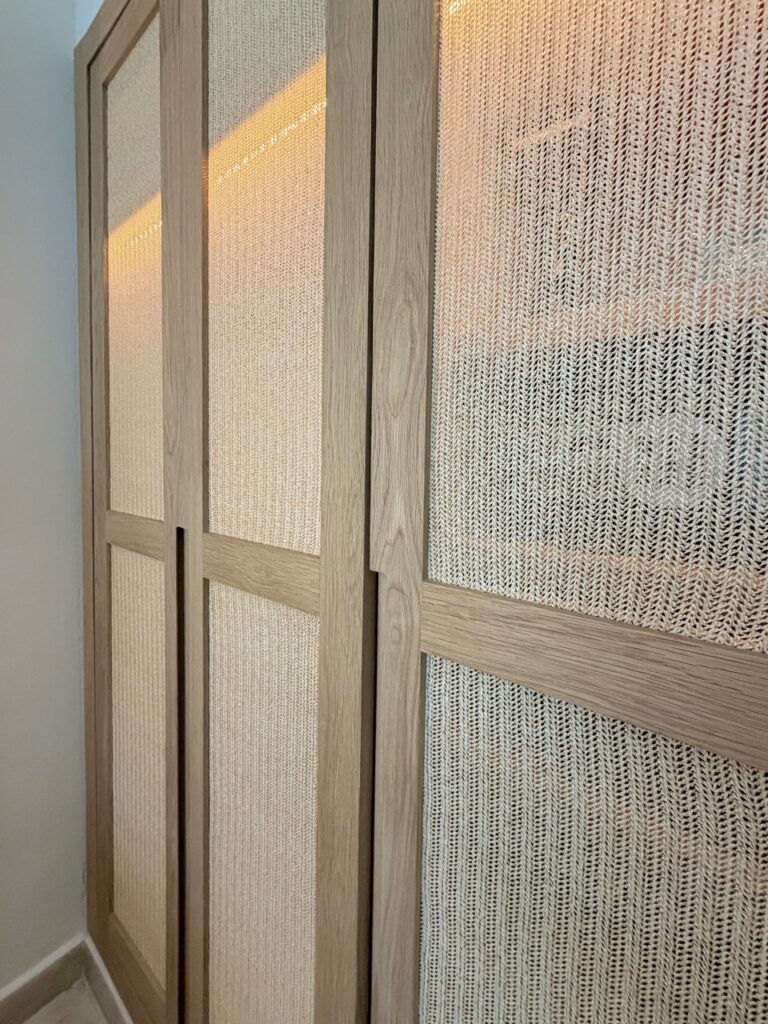 Puertas de closet con marco de madera y paneles tejidos iluminados desde el interior