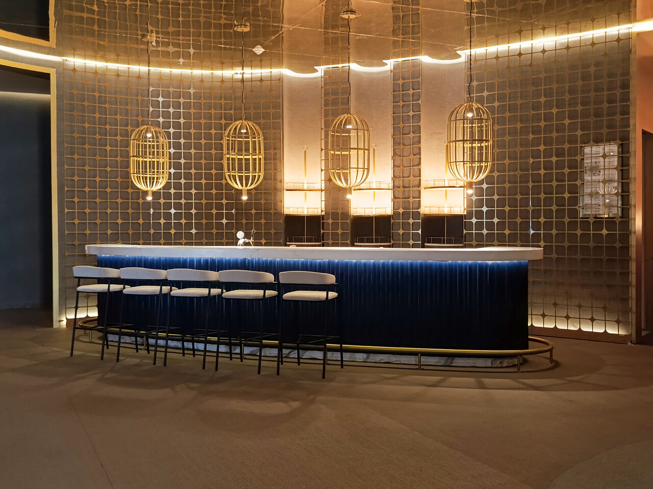 Barra curva en azul profundo bajo lámparas jaula, lobby espera restaurantesGrand Princess