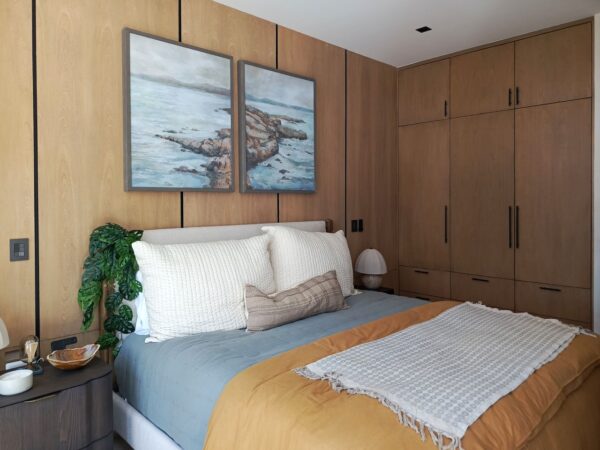 Recámara con clóset de madera y arte de paisaje marino, Casa Anexa Vida