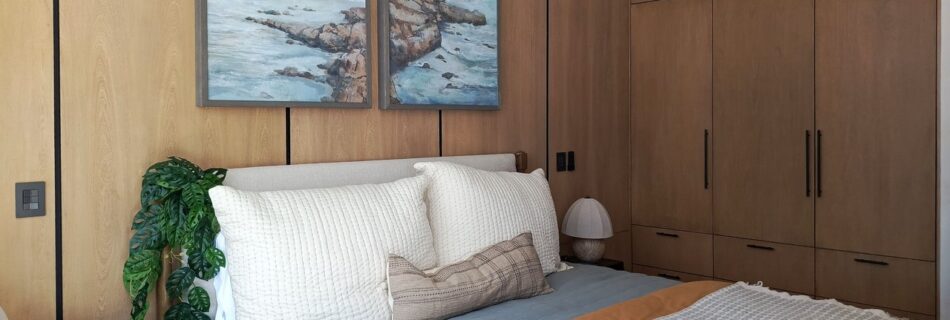 Recámara con clóset de madera y arte de paisaje marino, Casa Anexa Vida