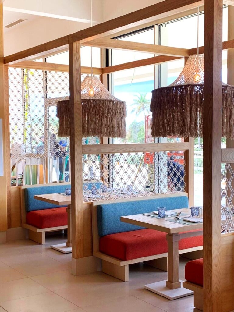 Booths con malla de cuerda y cojines en azul y rojo, Marea