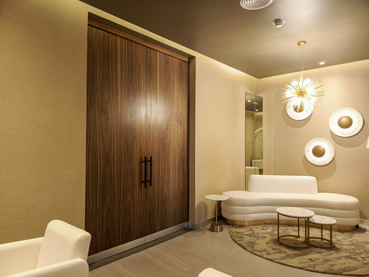 Puertas de madera y sofá curvo en lounge del spa, Grand Riviera Princess