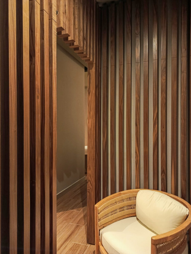 Celosía de madera con sillón de ratán en cabina del spa