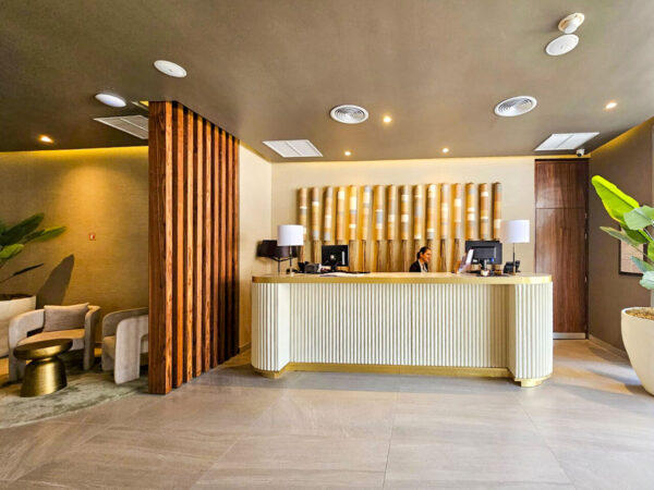 Recepción del spa con celosía de madera y papel tapiz enrollado, vista amplia